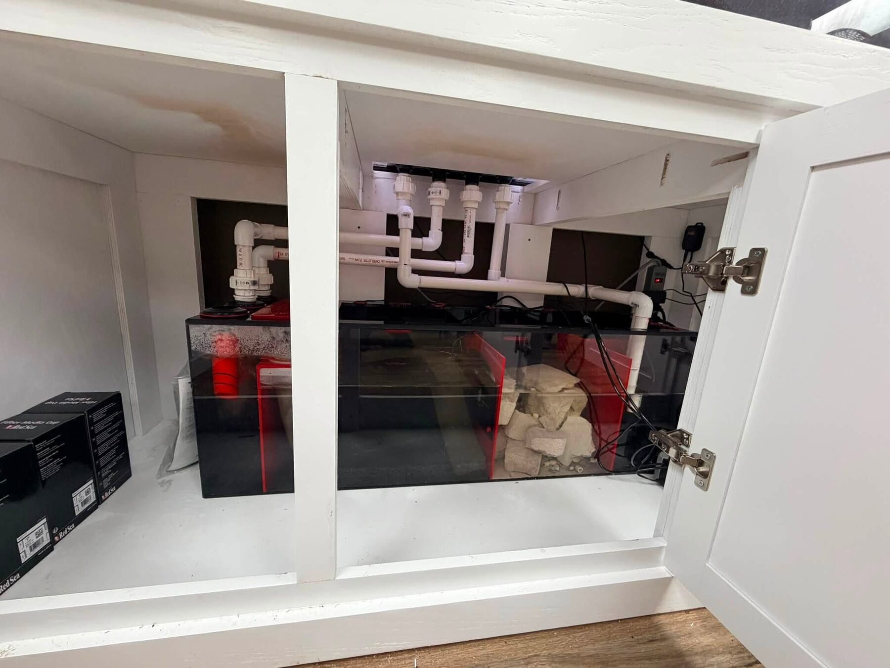 A sump and filtration setup installed beneath an aquarium stand